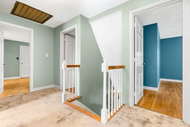 a view of a hallway with wooden floor and entryway