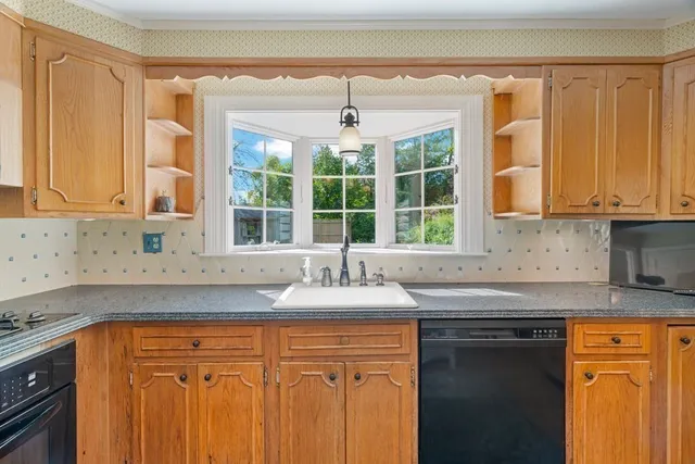a kitchen with granite countertop cabinets sink and window