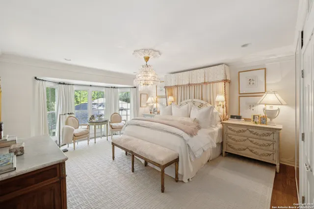 a bedroom with a bed large window with table and chairs