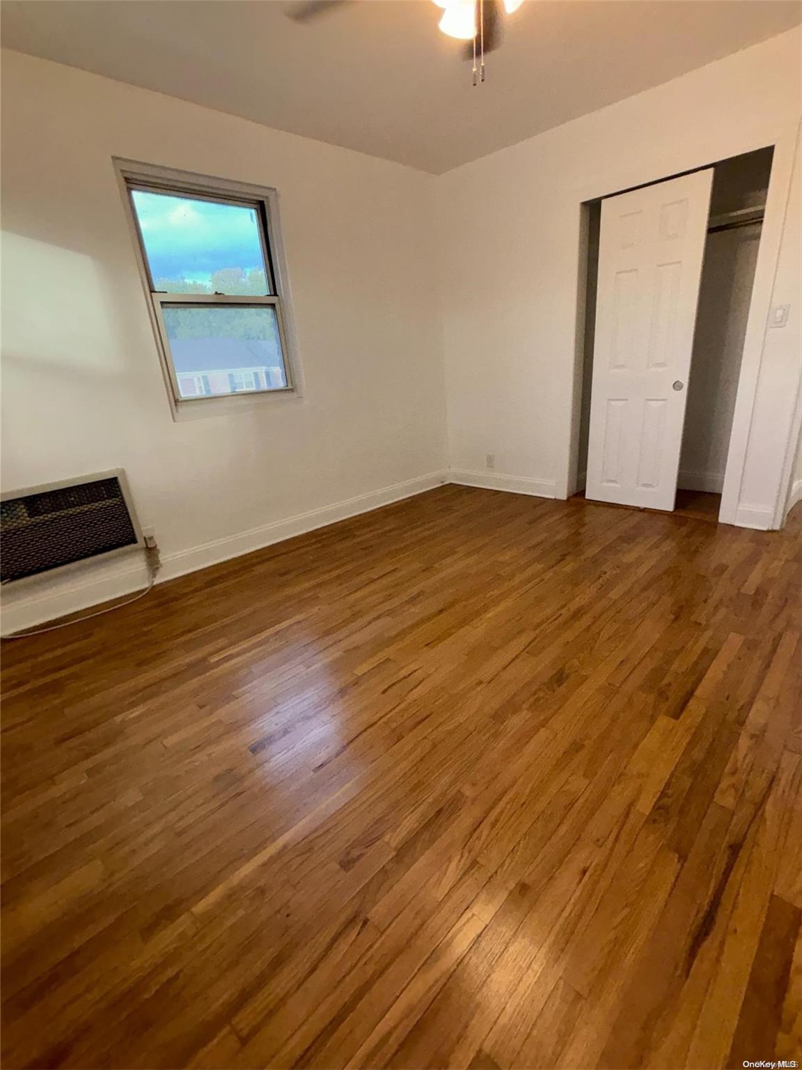 1033 Rottkamp Street, Unit 3 Valley Stream, NY 11580 - Photo 1 of 1 a view of an empty room with wooden floor and a window