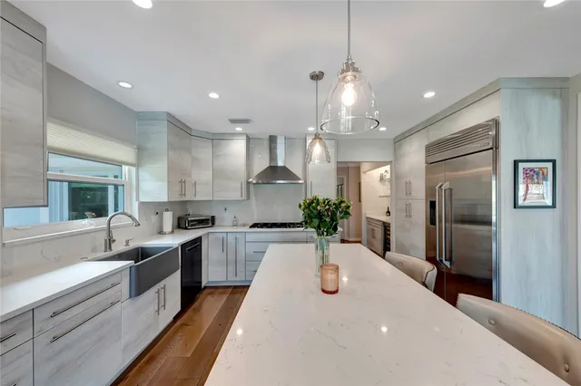 a large kitchen with kitchen island a large counter top stainless steel appliances and cabinets