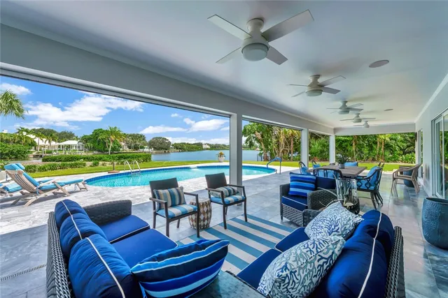 a view of a patio with couches potted plants and a big yard