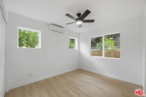 a view of a big room with wooden floor and windows