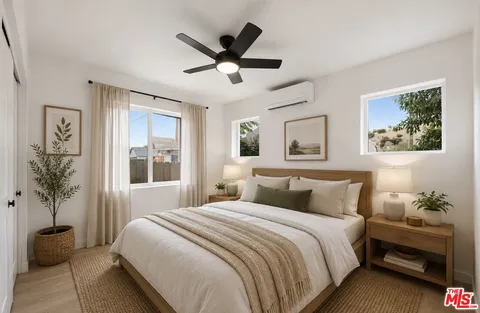 a bedroom with a large bed and a potted plant