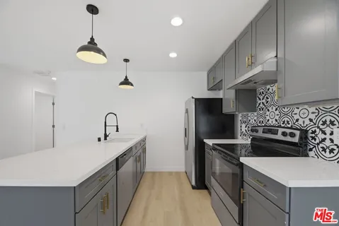 a kitchen with a sink stainless steel appliances and cabinets