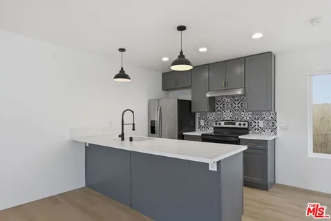 a kitchen with kitchen island stainless steel appliances a sink and cabinets