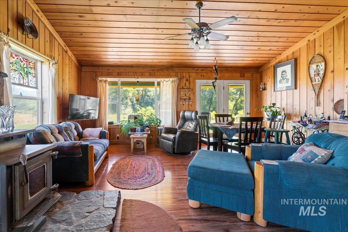2128 Jackson Creek Road Council, ID 83612 - Photo 11 of 50 Living area featuring wooden walls, wood ceiling, wood finished floors, and ceiling fan