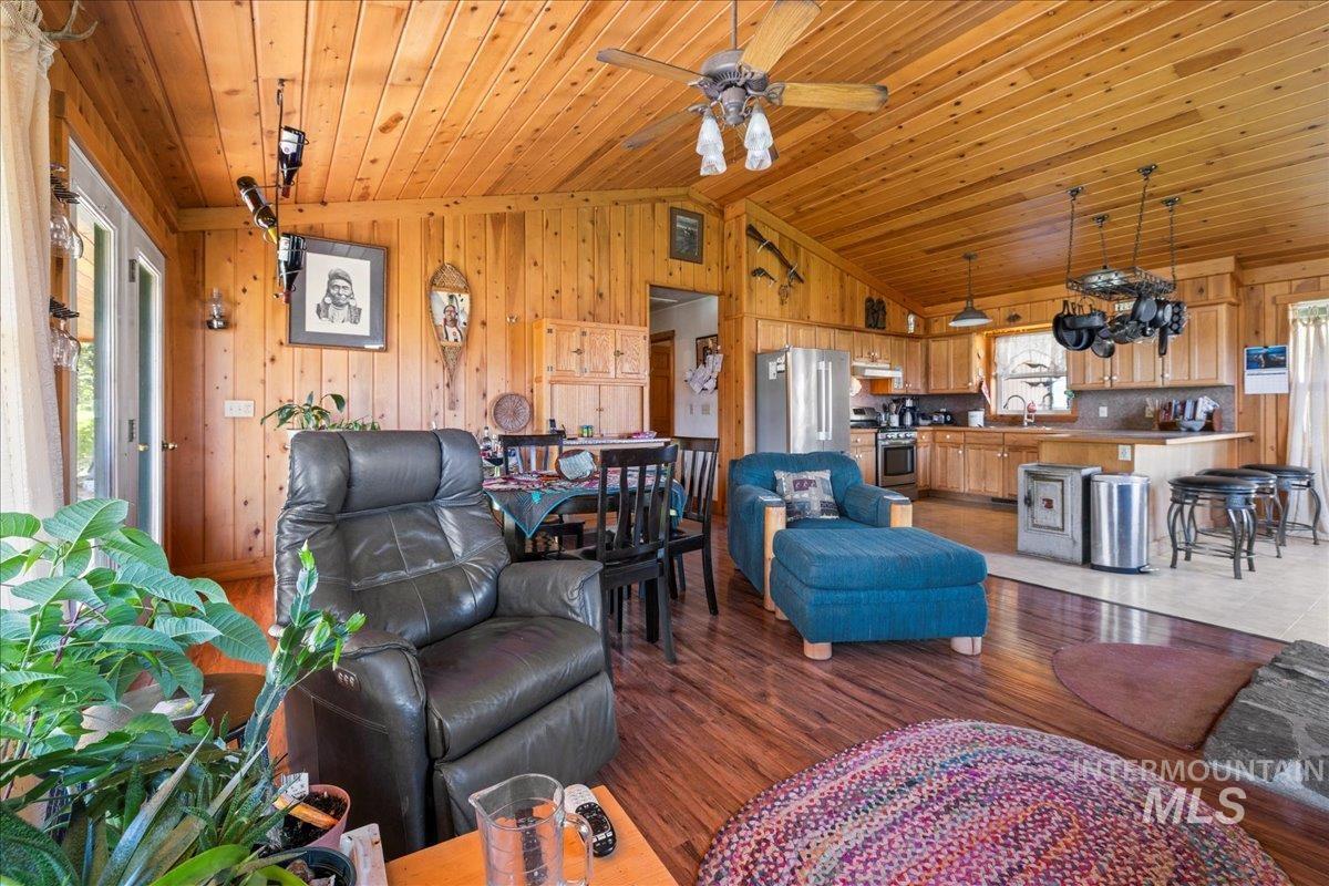2128 Jackson Creek Road Council, ID 83612 - Photo 13 of 50 Living area with vaulted ceiling, wood finished floors, wooden walls, wood ceiling, and a ceiling fan