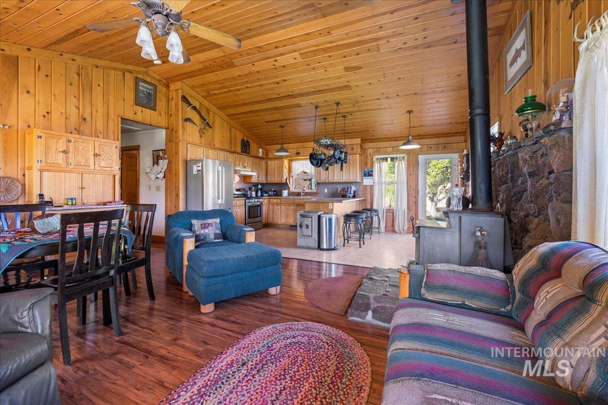 2128 Jackson Creek Road Council, ID 83612 - Photo 14 of 50 Living room with a wood stove, wood walls, wooden ceiling, wood finished floors, and high vaulted ceiling