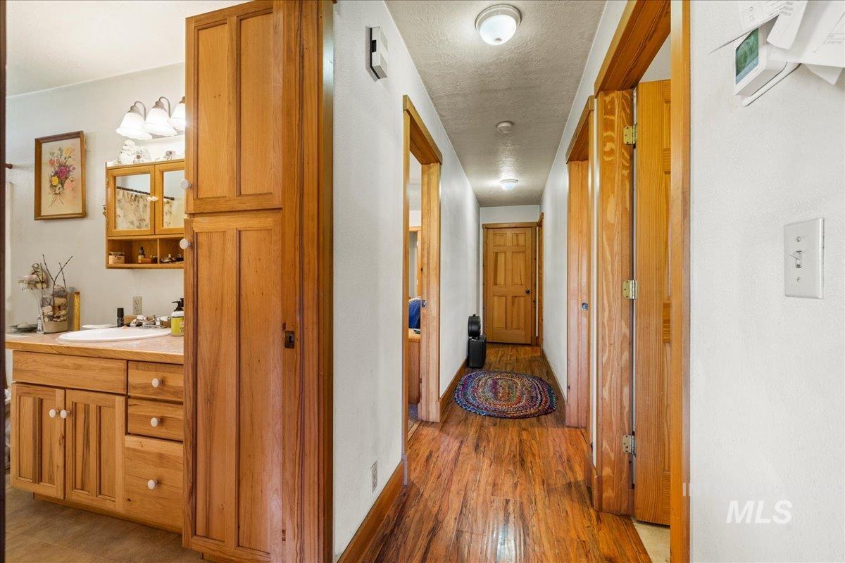 2128 Jackson Creek Road Council, ID 83612 - Photo 23 of 50 Corridor featuring light wood-style flooring and a textured ceiling