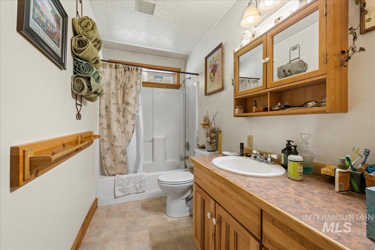 2128 Jackson Creek Road Council, ID 83612 - Photo 24 of 50 Bathroom with shower / bath combo, vanity, and a textured ceiling