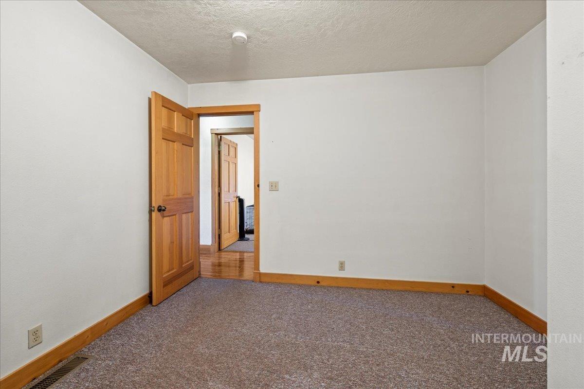 2128 Jackson Creek Road Council, ID 83612 - Photo 25 of 50 Carpeted empty room featuring a textured ceiling and baseboards