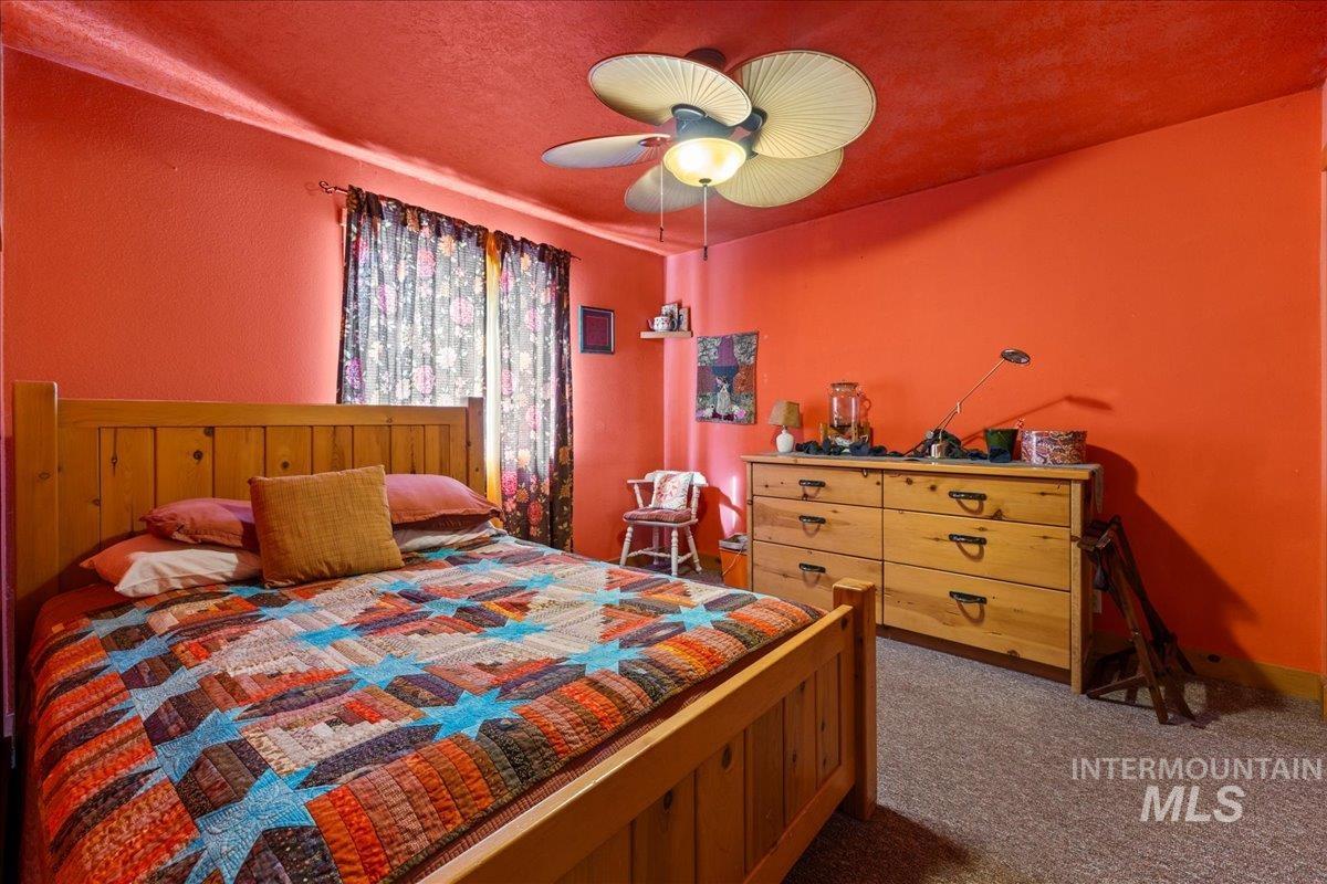 2128 Jackson Creek Road Council, ID 83612 - Photo 29 of 50 Bedroom with dark carpet, a ceiling fan, and a textured ceiling