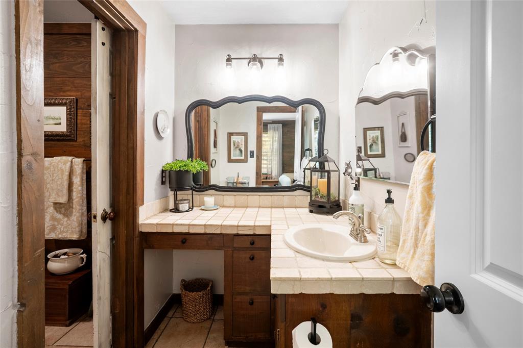 1516 Rancho Road Quinlan, TX 75474 - Photo 20 of 40 a bathroom with double vanity sinks a mirror and a shower