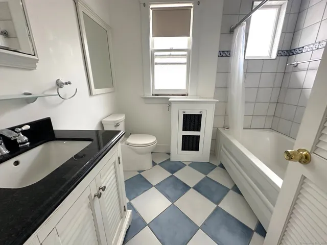 a bathroom with a granite countertop sink toilet and shower