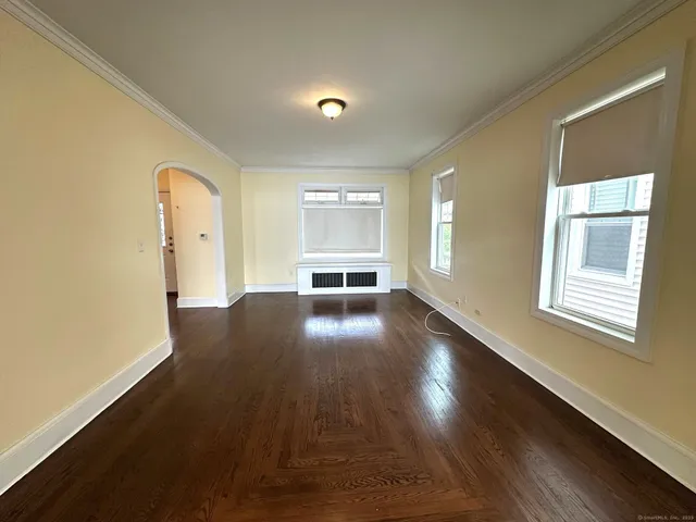 a view of empty room with wooden floor and windows