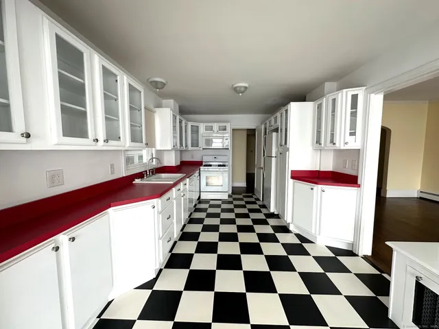a kitchen with a checkered floor and white cabinets