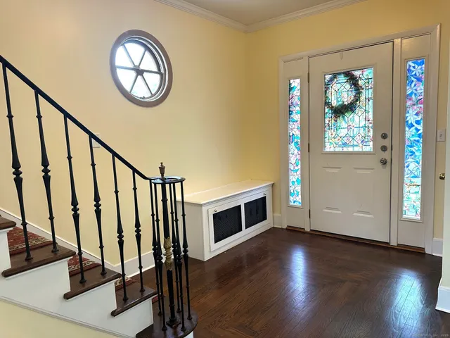 a view of a hallway with wooden floor and staircase