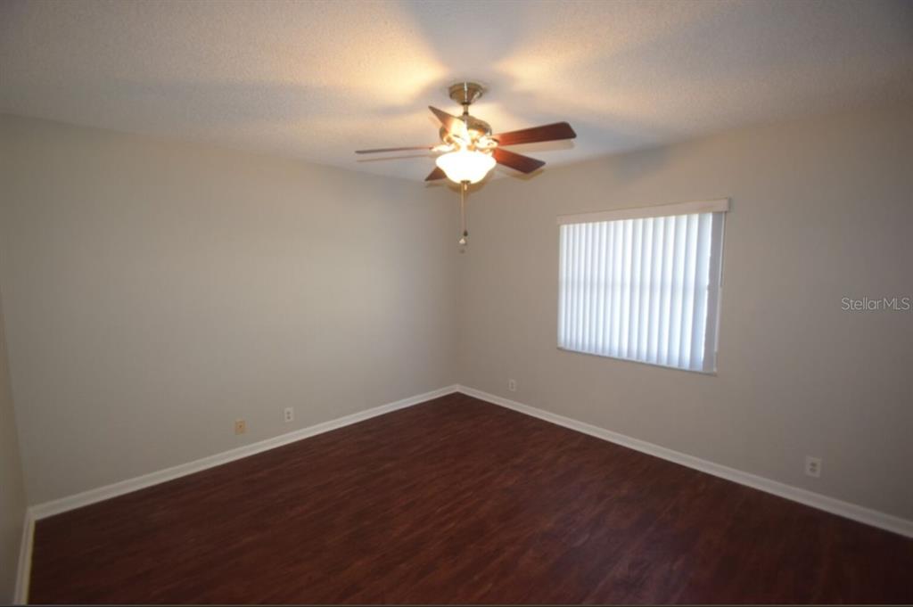 145 Audubon Road Winter Haven, FL 33884 - Photo 19 of 24 an empty room with wooden floor ceiling fan and window