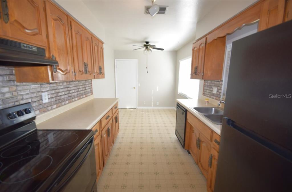 145 Audubon Road Winter Haven, FL 33884 - Photo 6 of 24 a kitchen with granite countertop a sink stove and cabinets