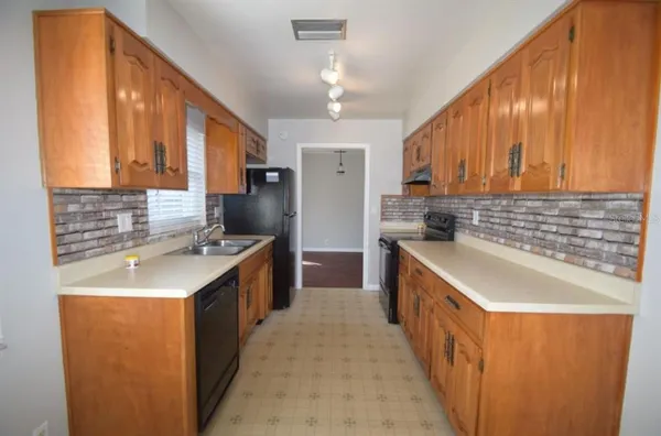 a kitchen with stainless steel appliances granite countertop a sink stove and cabinets
