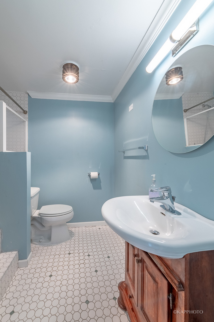 5455 North Sheridan Road, Unit 2008 Chicago, IL 60640 - Photo 12 of 35 a bathroom with a sink a toilet and a mirror