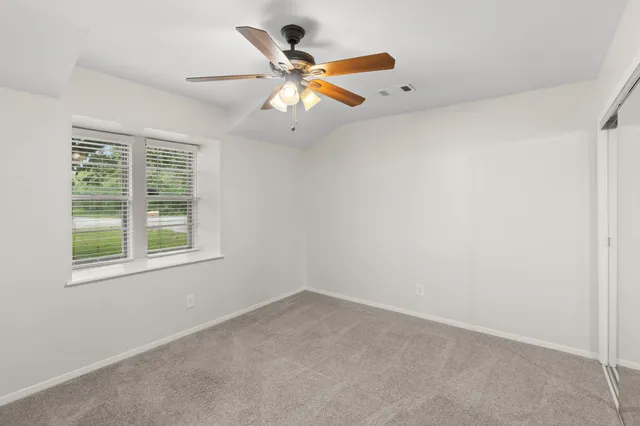 an empty room with a window and a fan