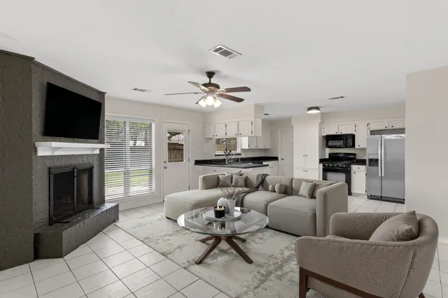 a living room with furniture a fireplace and a flat screen tv