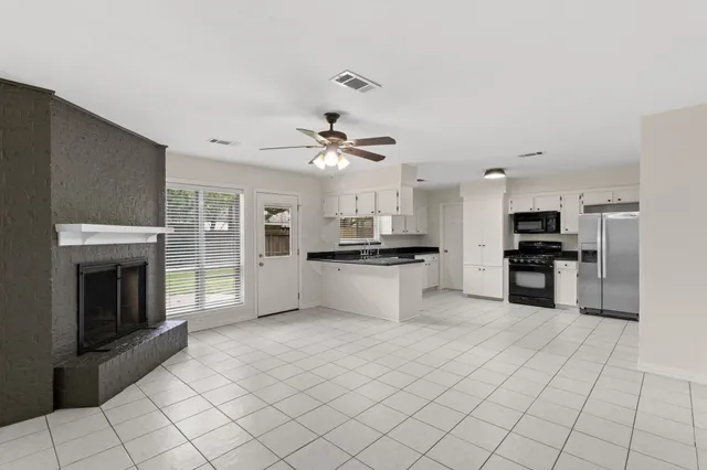 a view of kitchen with kitchen island granite countertop a stove top oven and cabinets