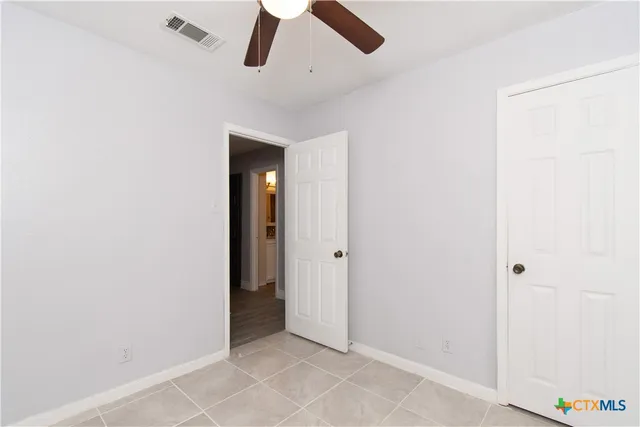 a view of room with a ceiling fan and window