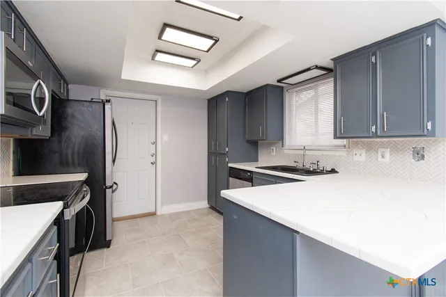 a kitchen with a sink a stove and a refrigerator