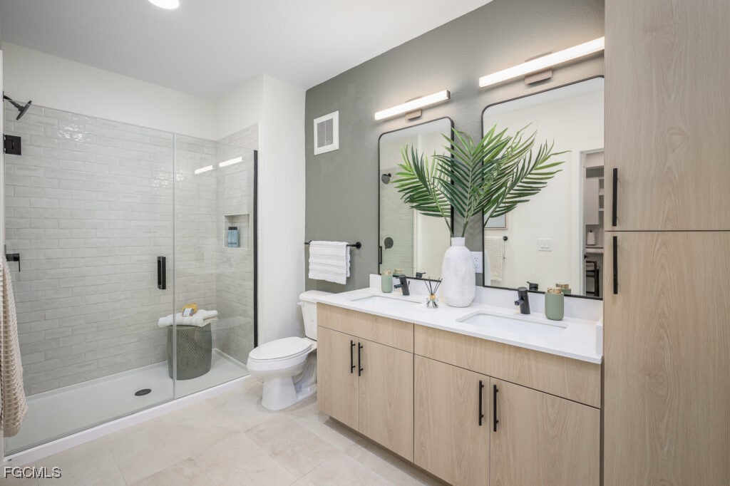 8552 Collier Boulevard, Unit RAVELLO Naples, FL 34114 - Photo 13 of 20 a bathroom with a sink a toilet and shower