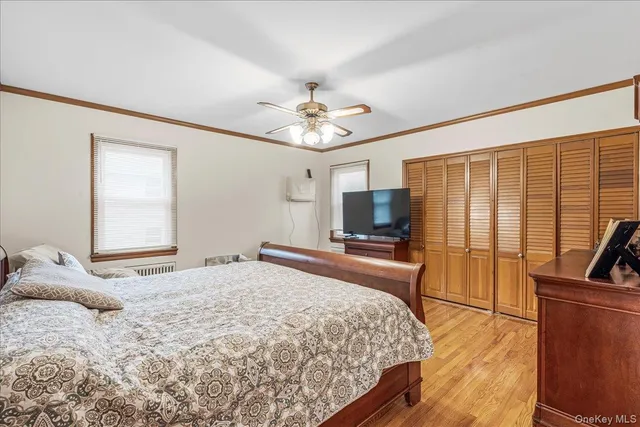 a bedroom with a bed a flat screen tv and a couch