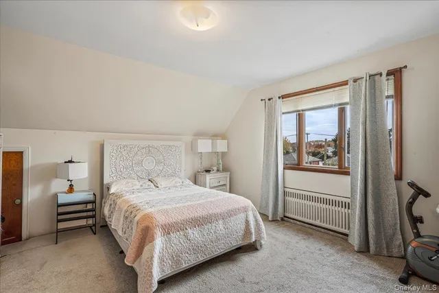 a bedroom with a bed a mirror and a window