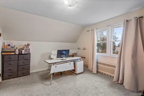 a view of a workspace with furniture and a window