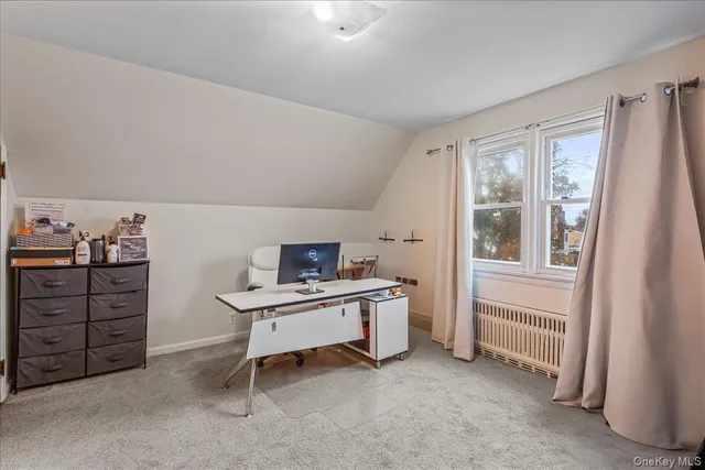 a view of a workspace with furniture and a window