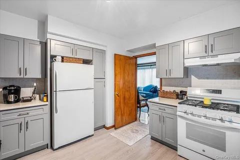 a kitchen with white cabinets and white appliances