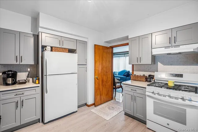 a kitchen with white cabinets and white appliances
