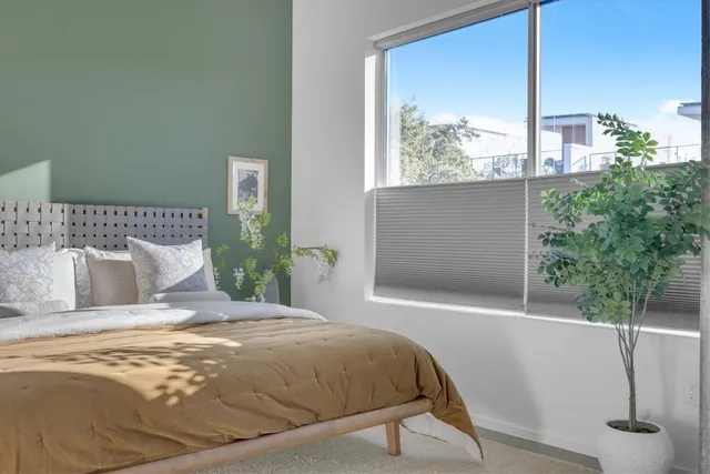 a large bed sitting in a bedroom next to a window