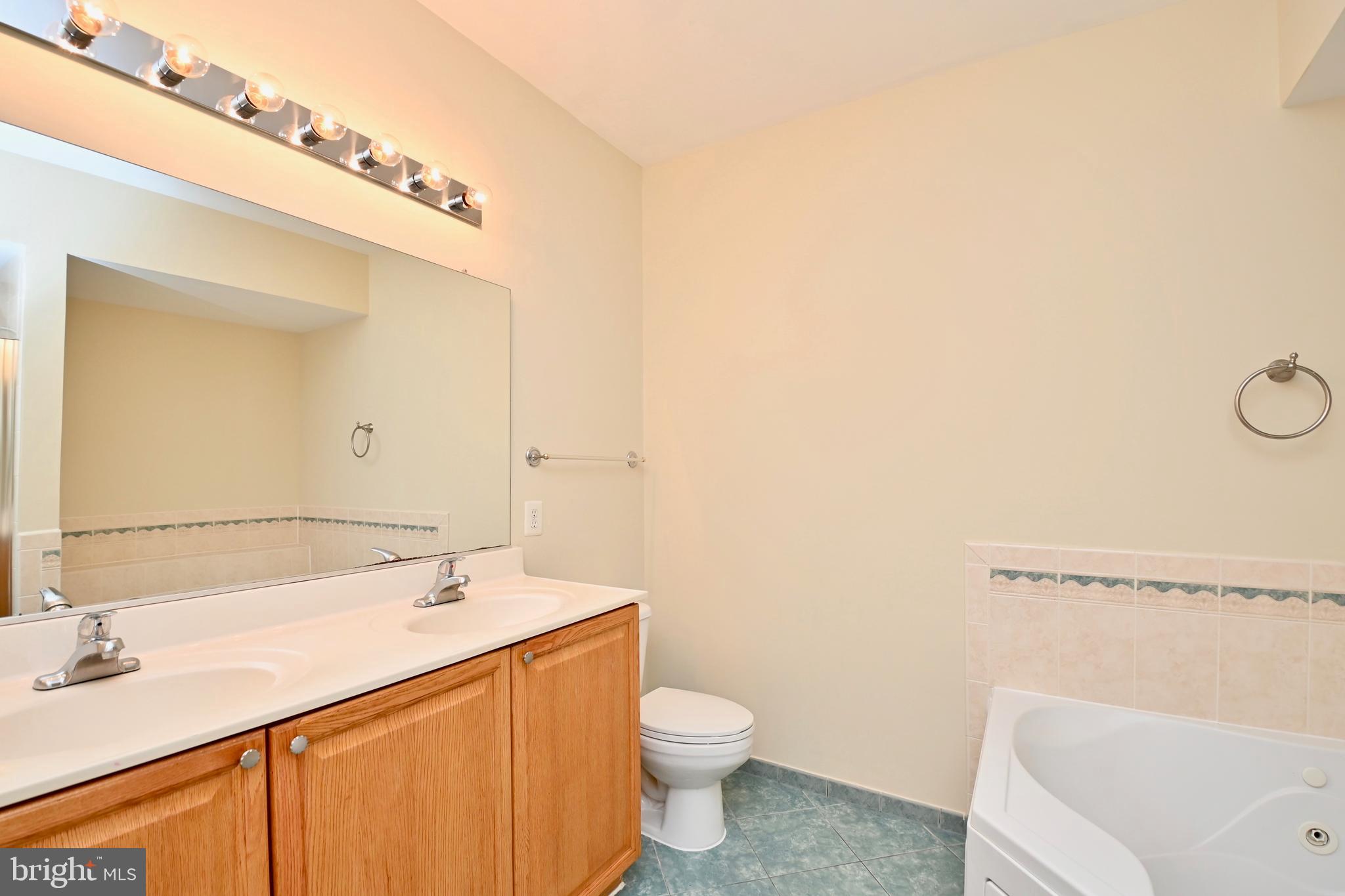 11775 Stratford House Place, Unit 104 Reston, VA 20190 - Photo 31 of 34 a bathroom with a sink a toilet and vanity