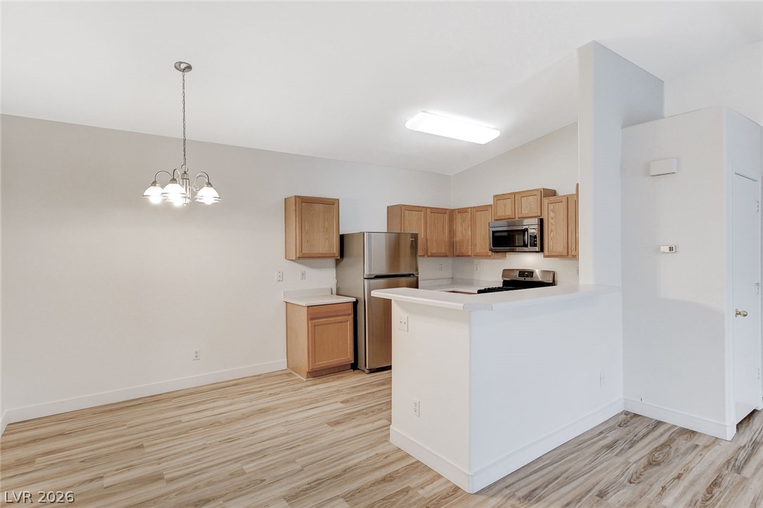 2052 Quarry Ridge Street, Unit 201 Las Vegas, NV 89117 - Photo 6 of 25 A well-lit kitchen with natural wood cabinetry and sleek stainless steel appliances awaits.