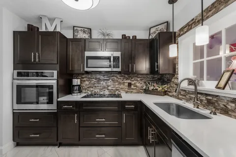 a kitchen with stainless steel appliances a sink cabinets and a refrigerator