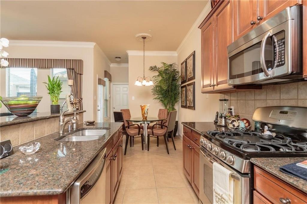 4673 Edith Street Plano, TX 75024 - Photo 14 of 35 a kitchen with stainless steel appliances granite countertop a stove a sink and a microwave