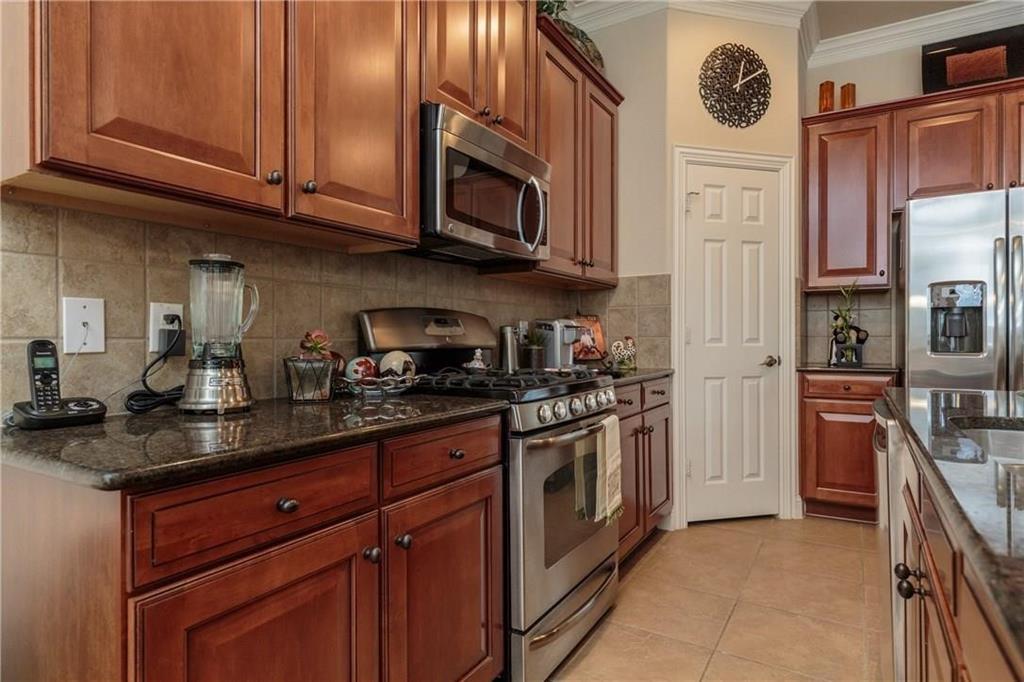 4673 Edith Street Plano, TX 75024 - Photo 15 of 35 a kitchen with stainless steel appliances granite countertop a stove a sink and a microwave