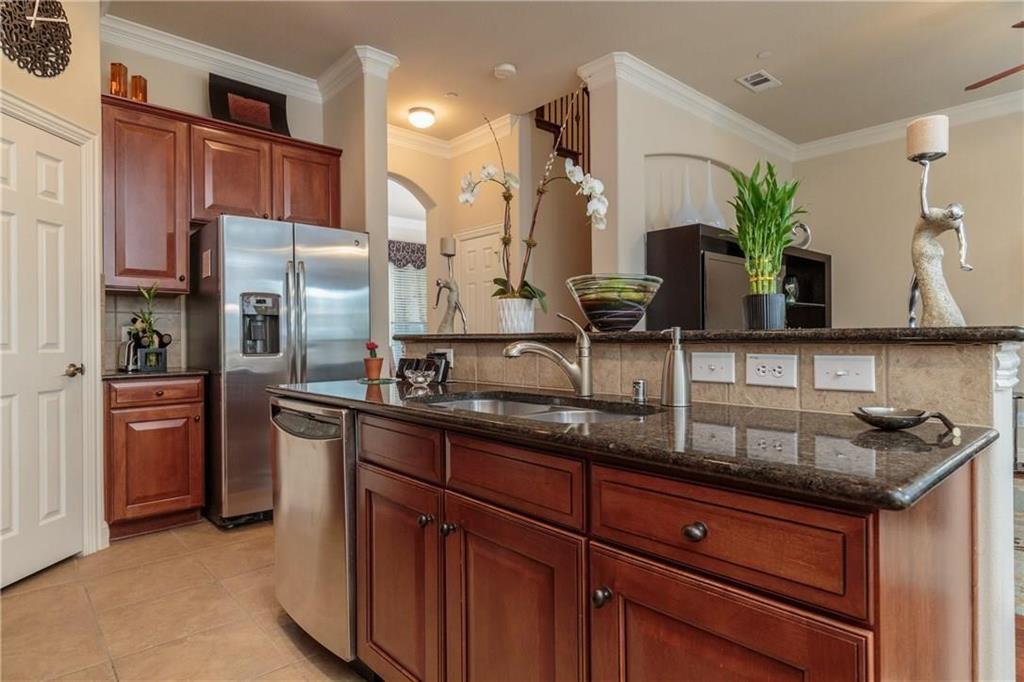 4673 Edith Street Plano, TX 75024 - Photo 16 of 35 a kitchen with stainless steel appliances granite countertop a sink and a refrigerator