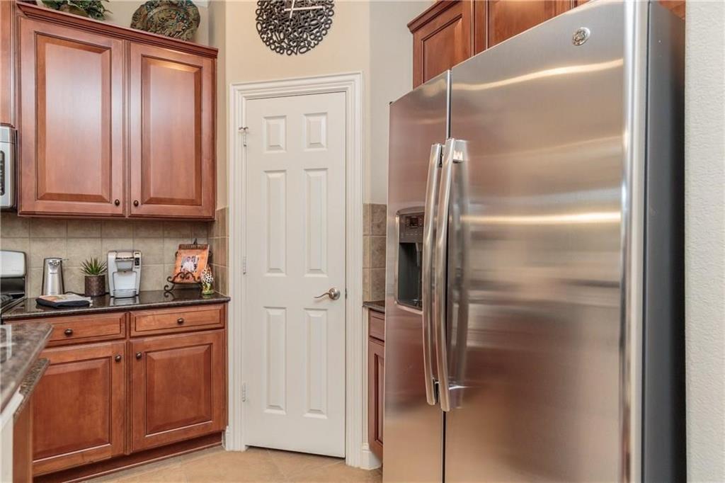 4673 Edith Street Plano, TX 75024 - Photo 18 of 35 a kitchen with stainless steel appliances granite countertop a refrigerator and cabinets