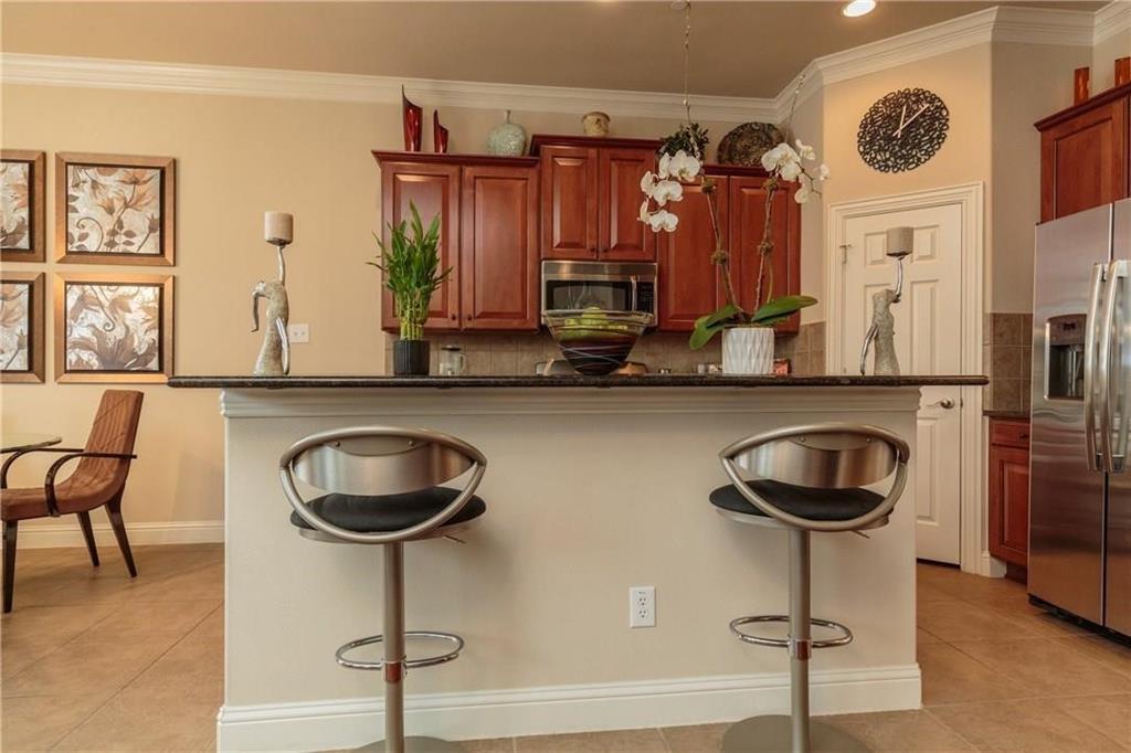 4673 Edith Street Plano, TX 75024 - Photo 19 of 35 a kitchen with a refrigerator and a chair