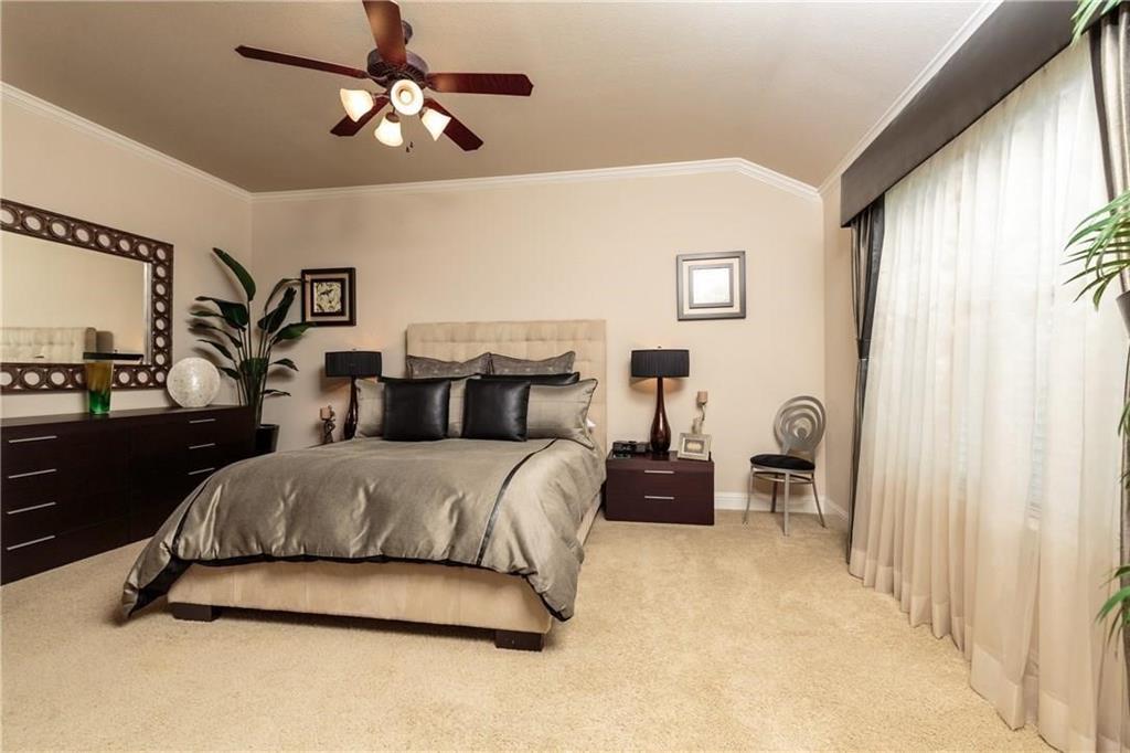 4673 Edith Street Plano, TX 75024 - Photo 27 of 35 a spacious bedroom with a bed and a chandelier