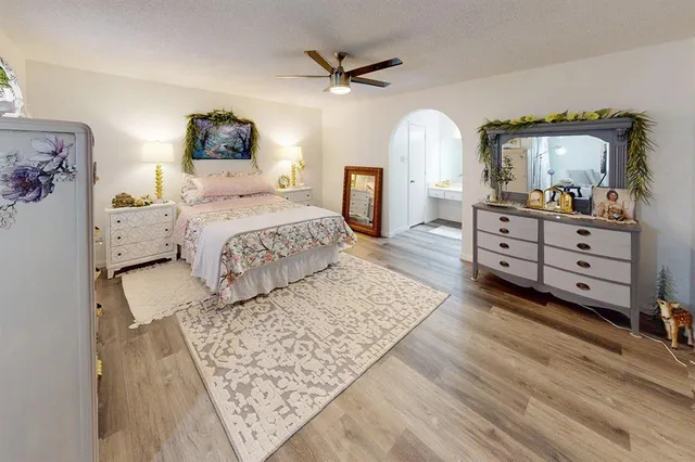 a bedroom with a large bed and a chandelier