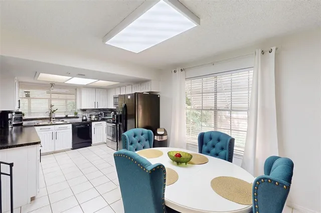 a kitchen with stainless steel appliances kitchen island granite countertop a kitchen island a stove a table and chairs